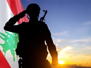 جندي من الجيش اللبناني يؤدي التحية العسكرية أمام العلم اللبناني