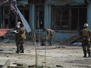 An Afghan investigator (C) inspect the remains of a body at the site where a suicide attacker blew himself up in a Shiite area of Kabul on Mar. 9, 2018. A suicide bomber on foot blew himself up in Kabul's Shiite area on Mar. 9, killing at least seven people, officials said, as militants dial up pressure on the war-weary Afghan capital.
(SHAH MARAI / AFP)