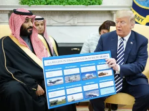 U.S. President Donald Trump (R) holds a defence sales chart with Saudi Arabia's Crown Prince Mohammed bin Salman in the Oval Office of the White House on Mar. 20, 2018 in Washington, DC. 
(MANDEL NGAN / AFP)