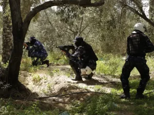 Hamas policemen take a position in Nuseirat, south of Gaza City on Mar. 22, 2018, during clashes as they carried out a man-hunt that resulted in the arrest of a suspect in a recent bomb attack against the Palestinian prime minister, officials said. 
(MAHMUD HAMS / AFP)