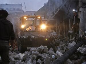 Members of the Syrian civil defence use a bulldozer to clear rubble as they search for survivors in the aftermath of an air strike in the rebel-held town of Harem in the northwestern Idlib province on Mar. 22, 2018. 
(Aaref WATAD / AFP)
