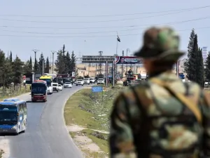 A convoy transporting Jaish al-Islam fighters and their families from the former bastion's main town of Douma arrives at the entrance to the northern Syrian city of Aleppo after being evacuated from the last rebel-held pocket in Eastern Ghouta on Apr. 3, 2018. 
(George OURFALIAN / AFP)