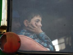 A child looks out of the window as buses carrying Jaish al-Islam fighters and their families from their former rebel bastion of Douma, arrive at the Abu al-Zindeen checkpoint controlled by Turkish-backed rebel fighters near the northern Syrian town of al-Bab, on Apr. 12, 2018. Rebels in Syria's Eastern Ghouta surrendered their heavy weapons and their leader left the enclave, a monitor said, signalling the end of one of the bloodiest assaults of Syria's seven-year war. (Nazeer al-Khatib / AFP)
