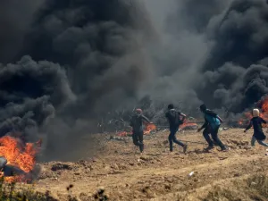 Palestinian protesters pull a metal cable as they try to take down a section of barbed wire at the border fence with Israel, east of Gaza City in the central Gaza Strip, on Apr. 13, 2018. Clashes erupted as thousands protested for a third consecutive Friday along Gaza's border with Israel after violence in which Israeli forces have killed 33 Palestinians and wounded hundreds of others. (MAHMUD HAMS / AFP)