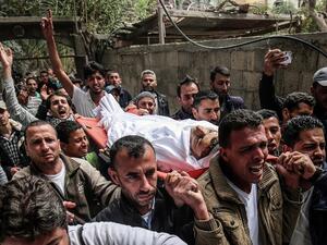 Mourners carry the body of 29-year-old Saadi Abu Taha who was killed during clashes along the Israel-Gaza border/ AFP