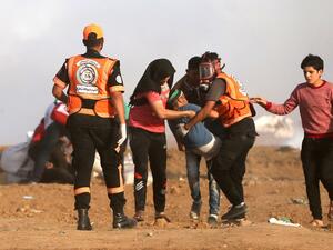Palestinians carry an injured protester during clashes with Israeli forces along the border with the Gaza strip east of Jabalia on May 18, 2018. (MOHAMMED ABED / AFP)