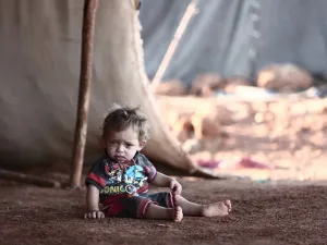 A child sits in front of a tent at a camp for the displaced from the rebel-held Syrian province of Idlib, at the village of al-Ghadfa, southeast of the province on September 2, 2018. (Nazeer AL-KHATIB / AFP)