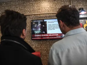 People watch on a TV the speech of Turkish president Recep Tayyip Erdogan (AFP)