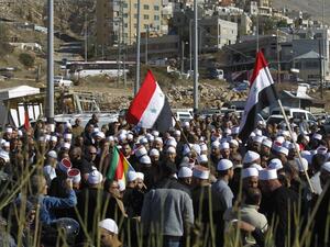 Druze men protest against municipal elections in front of a polling centre in the village of Majdal Shams in the Israeli-annexed Golan Heights on October 30, 2018 (AFP)