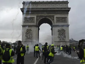 Protestors of the yellow vest (gilet jaune) movement walk past the Arc of Triomphe on the Champs Elysees in Paris, on November 24, 2018 during a protest against rising oil prices and living costs. (AFP)