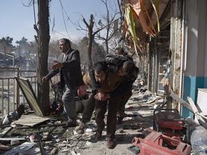 Afghan volunteers carry a body at the scene of a car bomb exploded in front of the old Ministry of Interior building in Kabul on January 27, 2018. (WAKIL KOHSAR / AFP)