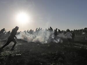 Palestinian protesters run through tear gas fumes during clashes with Israeli forces following a demonstration along the border with Israel east of Gaza City on January 11, 2019. (MAHMUD HAMS / AFP)
