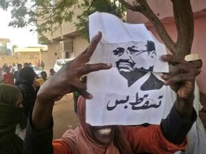 A Sudanese protester carries a portrait of President Omar al-Bashir with Arabic writing that reads "down and that is all" during an anti-government demonstration east of the capital Khartoum on February 8, 2019. (AFP)