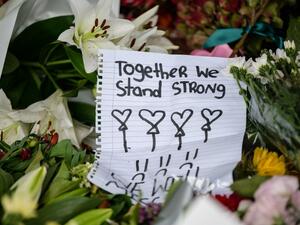 A handwritten note is displayed among flowers during a vigil in Christchurch (AFP)