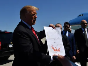 US President Donald Trump show a map which he said indicates the end of ISIS, as he arrives at Palm Beach International Airport in Florida on March 22, 2019. (Nicholas Kamm / AFP)
