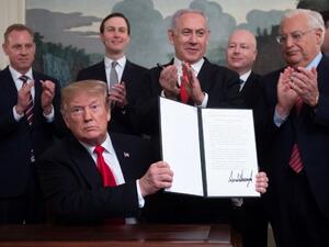 US President Donald Trump holds up a signed Proclamation on the Golan Heights alongside Israeli Prime Minister Benjamin Netanyahu in the Diplomatic Reception Room at the White House in Washington (AFP)
