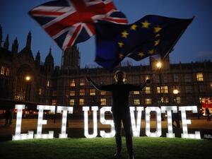 An anti-Brexit activist waves the Union and EU flags near the Houses of Parliament in central London on March 27, 2019. (Tolga AKMEN / AFP)
