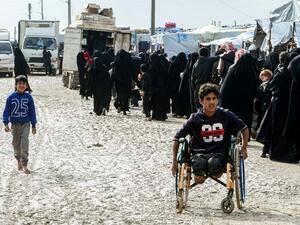 Veiled women, living in al-Hol camp which houses relatives of Islamic State (IS) group members, stand in queue to receive goods in the camp in al-Hasakeh governorate in northeastern Syria on March 28, 2019. 
GIUSEPPE CACACE / AFP 