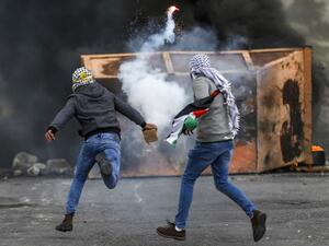 A Palestinian man throws back a tear gas canister during clashes with Israeli forces following a demonstration marking "Land Day" in the occupied West Bank on March 30, 2019. (AFP/ File photo) A Palestinian man throws back a tear gas canister during clashes with Israeli forces following a demonstration marking "Land Day" in the occupied West Bank on March 30, 2019. (AFP/ File photo)