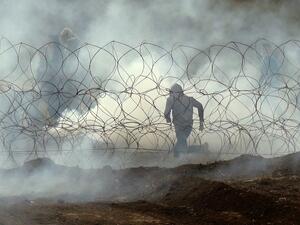 Palestinian protester running away from the border fence, as Palestinians demonstrate to mark the first anniversary of the "March of Return" protests. (Jack GUEZ / AFP)