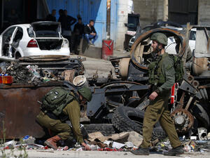 Israeli soldiers inspect the site where a Palestinian man was killed after he reported tried to stab an Israeli driver at a junction south of Nablus in the occupied West Bank on April 3, 2019. (JAAFAR ASHTIYEH / AFP)