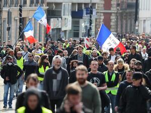 Demonstrators, some waving French national flags, walk in the streets of Rouen during a "Yellow Vests" protest on April 6, 2019 for the 21st consecutive Saturday. (KENZO TRIBOUILLARD / AFP) 
