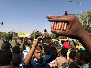 A Sudanese protester shows bullet cartridges as others gather in front of security forces during a demonstration in the area of the military headquarters in the capital Khartoum on April 8, 2019. (AFP)