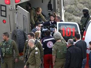 Israeli security forces stand next to a stretcher carrying the body of Haitham al-Bau as they hand over the body to members of the Palestinian Red Crescent on February 5, 2016. (AFP/Hazem Bader)