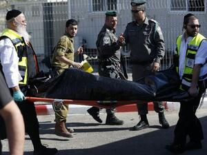 Ultra-Orthodox Jewish Zaka volunteers carry away on a stretcher the body of a Palestinian assailant who was shot dead following a reported attempt to stab Israeli border police, at a checkpoint near the Israeli settlement of Har Homa, between Jerusalem and Bethlehem in the occupied West Bank, on February 14, 2016. (AFP/Ahmad Gharabli)