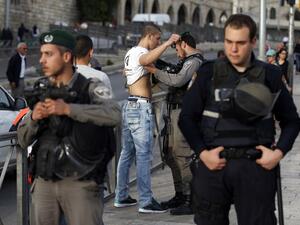 Israeli security forces body-check a Palestinian young man at the entrance of Damascus Gate, outside Jerusalem's Old City, on March 9, 2016. (AFP/Ahmad Gharabli)