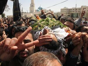 Mourners carry the body of Palestinian Mahmud Abu Fanuna during his funeral on March 19, 2016, in Hebron in the south of the Israeli-occupied West Bank. (AFP/Hazem Bader)
