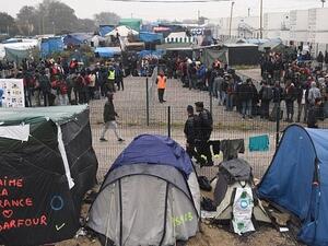 Migrants line up for transportation by bus to reception centers across France, from the "Jungle" migrant camp in Calais, northern France, on Oct. 24, 2016 (FRANCOIS LO PRESTI/AFP)