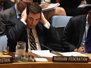Russia's deputy UN ambassador, Vladimir Safronkov, covers his ears during a Security Council debate on Syria, April 5 2017. (AFP/Timothy A. Clary)