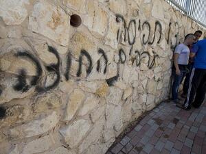 Arab Israeli men stand next to graffiti reading in Hebrew "Arabs Out" on the wall of a mosque in the northern Israeli city of Umm al-Faham on April 18, 2014 (JACK GUEZ / AFP) Arab Israeli men stand next to graffiti reading in Hebrew "Arabs Out" on the wall of a mosque in the northern Israeli city of Umm al-Faham on April 18, 2014 (JACK GUEZ / AFP)
