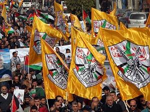 Palestinian demonstrators hold Fatah party flags as they demonstrate in the center of the West Bank city of Hebron. (AFP/HAZEM BADER)
 Palestinian demonstrators hold Fatah party flags as they demonstrate in the center of the West Bank city of Hebron. (AFP/HAZEM BADER)