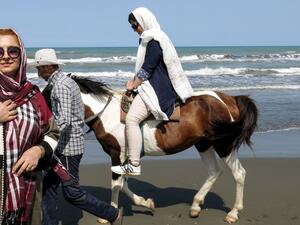 An Iranian woman rides a horse by the Caspian Sea coast in the port city of Gisum, in the northern province of Gilan on August 23, 2017. (AFP)