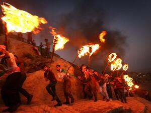 Iraqi Kurds wave Kurdish flags and hold torches as they walk up a mountain during a gathering to show support for the upcoming independence referendum and encourage people to vote in the town of Akra, some 500 kilometres north of Baghdad on September 10, 2017. (SAFIN HAMED / AFP)