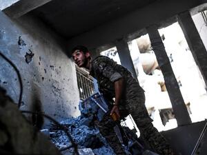An SDF fighter looks out from a ruined building in Raqqa, AFP 