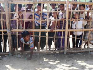 A young Rohingya Muslim refugee passes through a temporary bamboo barricade to collect cooked food at the Thankhali refugee camp in Bangladesh's Ukhia district on Nov. 10, 2017 (AFP)