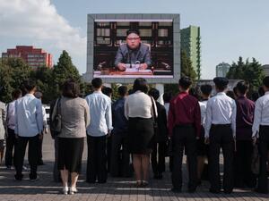 Spectators listen to a television news broadcast of a statement by North Korean leader Kim Jong-Un, before a public television screen outside the central railway station in Pyongyang on Sept. 22, 2017 (Ed JONES/AFP)