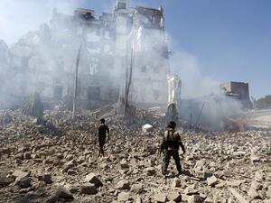 Huthi rebel fighters inspect the damage after a reported air strike carried out by the Saudi-led coalition targeted the presidential palace in the Yemeni capital Sanaa on Dec. 5, 2017 (Mohammed Huwais/AFP)