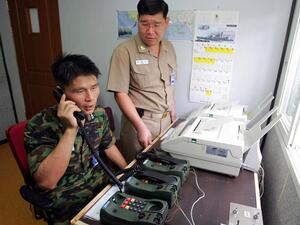 This file photo taken on Aug. 10, 2005 shows South Korean Lieutenant Choi Don-Rim (L) communicating with a North Korean officer during a phone call at a military office as the two countries tested a hotline aimed at helping avoid naval confrontations in the Yellow Sea (AFP/File)