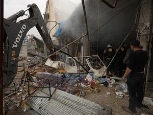 Members of the Syrian Civil Defence, known as the White Helmets, clear the rubble at the scene of a reported air strike on a market in the city of Maaret al-Numan in Syria's rebel-held Idlib province on Jan. 3, 2018 (OMAR HAJ KADOUR / AFP)