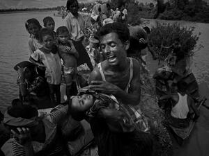 A Rohingya refugee reacts while holding his dead son after crossing the Naf river from Myanmar into Bangladesh in Whaikhyang on Oct. 9, 2017 (INDRANIL MUKHERJEE / AFP)