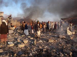 Smoke rises as Yemenis inspect the damage at the site of air strikes in the northwestern Huthi-held city of Saada, on Jan. 6, 2018 (STRINGER / AFP)