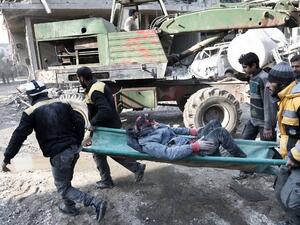 Volunteers from the Syrian Civil Defence (known as the White Helmets) carry a girl on a stretcher after digging her out of the rubble following an air strike on Hamouria, in the besieged rebel-held Eastern Ghouta on Jan. 9, 2018 (ABDULMONAM EASSA / AFP)