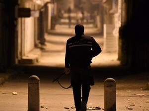 A member of the Tunisian security forces stands across protesters during clashes in the Ettadhamen on the outskirts of Tunis late on Jan. 10, 2018 (FETHI BELAID / AFP)