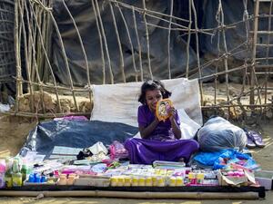A Rohingya Muslim refugee applies lipstick as she waits for customers at a stall in Kutupalong refugee camp in Bangladesh's Ukhia district on Jan. 12, 2018 (Munir UZ ZAMAN / AFP)