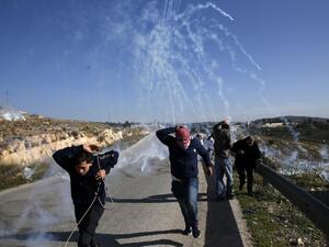 Palestinians run for covers from smoke-grenades during clashes with Israeli security forces following a demonstration in support of Palestinian prisoners on Jan. 13, 2018 (ABBAS MOMANI / AFP) Palestinians run for covers from smoke-grenades during clashes with Israeli security forces following a demonstration in support of Palestinian prisoners on Jan. 13, 2018 (ABBAS MOMANI / AFP)