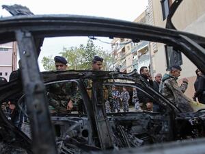 Lebanese security forces check a damaged vehicle following a car bomb blast in the southern Lebanese port city of Sidon on Jan. 14, 2018 (Mahmoud ZAYYAT / AFP)